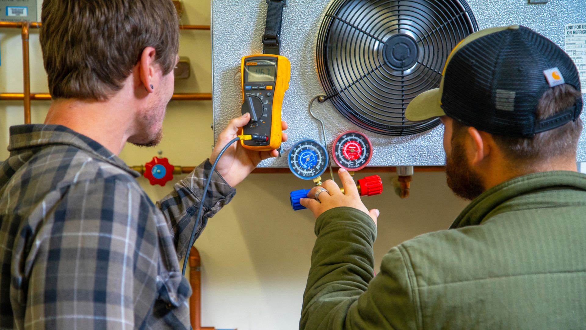 Two male students look at electronics